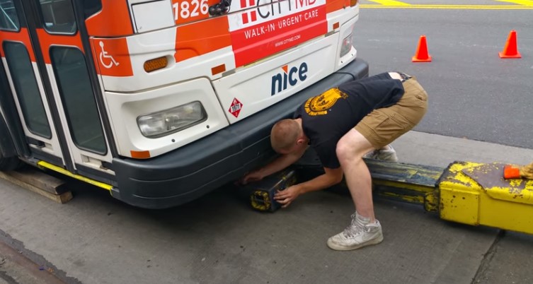 Man attaching the towing vehicle to the bus